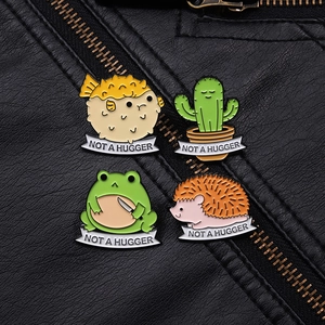 Set of four metal enamel badges featuring pufferfish, cactus, frog and hedgehog designs
