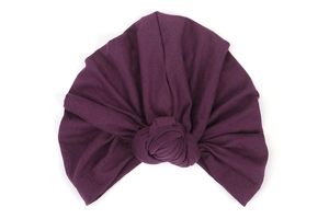 Detailed view of the twisted knot design on a dark purple stretch knit turban headscarf