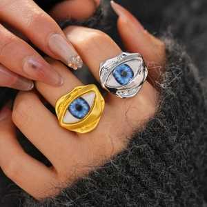 Macro shot of irregular blue eye resin ring with gold plating on model finger