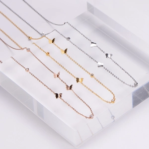 Trois colliers papillon en or, argent et or rose avec des accents de zircon brillants