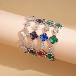 Gros plan de bracelets trèfle élégants avec des pierres de zircon colorées en divers tons