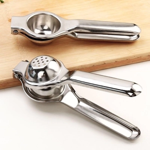 Manual stainless steel lemon squeezer and fruit juicer set on a wooden board