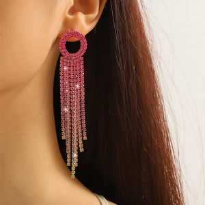 Close-up of pink rhinestone long tassel earrings showing luxurious shimmer on a model