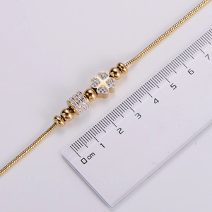 Macro shot showing the 3cm diamond-set clover charm on a gold-plated snake chain bracelet
