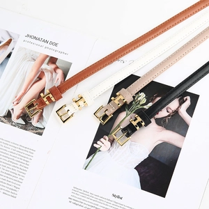 Dettaglio di quattro cinture sottili con fibbie ad H dorate in marrone, bianco, beige e nero
