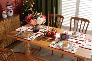Detail of Christmas table runner set with red snowflakes, Santa motifs and white tassels
