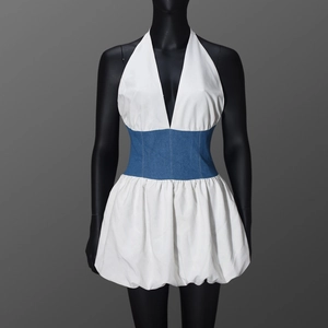 Détail d'une robe dos nu avec tissu blanc et empiècement en denim bleu à la taille