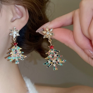 Close-up of model wearing Christmas tree earrings with colorful crystals and pearls