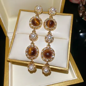 Vintage style drop earrings with pearls, brown cat-eye stones, and sparkling zircons