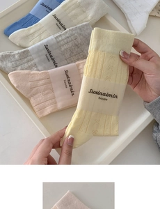 Detailed close-up of soft cotton socks with elegant bow patterns in multiple pastel colors