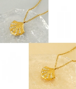 Detail of fan-shaped shell pendant in gold-plated stainless steel with inlaid diamonds
