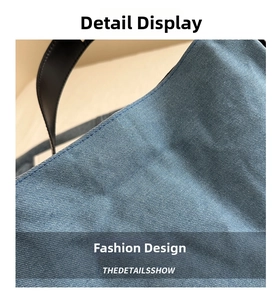 Detail der blauen Denim-Struktur und schwarzem Lederriemen mit präziser Nahtverarbeitung