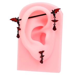 Gothic red bat industrial barbell and earring set with red teardrop gems on ear model