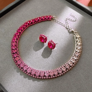 Detailaufnahme von Halskette mit rosa Farbverlauf und passenden Strass-Ohrringen