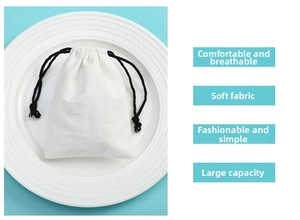Macro shot of white breathable cotton jewelry pouch with drawstring on a blue background