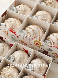 Macro detail of champagne gold Christmas balls with gold bead patterns in a gift box