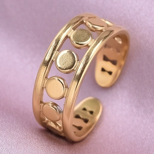 Detailed close-up of a hollow geometric gold ring displayed on soft pink silk fabric