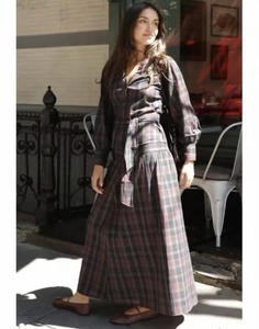 Foto street style di un abito lungo a quadri scuri con cintura in vita e maniche a sbuffo