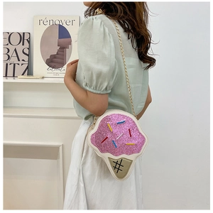 Detail of pink glitter ice cream crossbody bag with gold chain strap on female model