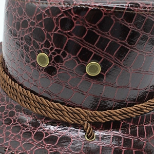 Detail of dark brown faux leather cowboy hat featuring crocodile texture and braided rope