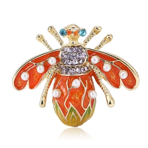Golden enamel honey bee brooch with white pearls and purple rhinestones on white background
