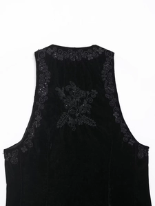 Detail shot of black velvet vest featuring exquisite tonal floral embroidery and beadwork
