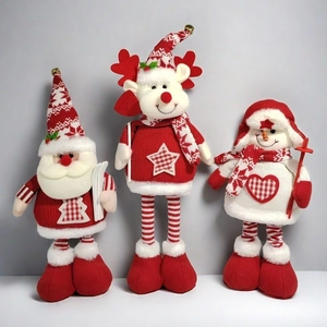 Detail of three plush Christmas dolls featuring Santa, reindeer, and snowman with knit textures