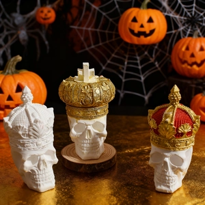 Dettagli di tre candele a teschio per Halloween con corone dorate e stile gotico