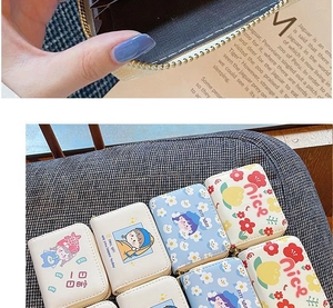 Detail of multi-slot accordion card holder with floral prints and zipper closure