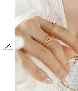 Detail of gold hollow扣 ring on hand showing high-quality polished stainless steel finish