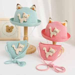 Close-up of woven texture on kids cartoon cat straw hat and matching crossbody bag