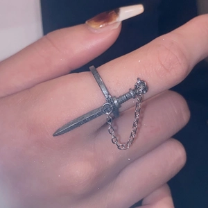 Detail van een gotische zwaardring met ketting in vintage zilveren afwerking aan de hand