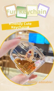 Detail of liquid sand keychain featuring a cute cartoon bear with golden star sequins