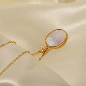 Détail du collier en acier inoxydable plaqué or 18K avec nacre blanche sur de la soie