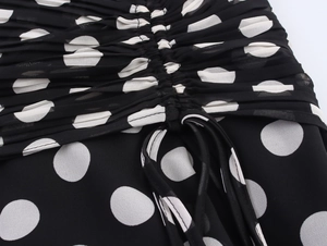 Macro shot of polka dot chiffon fabric featuring drawstring waist and pleated texture