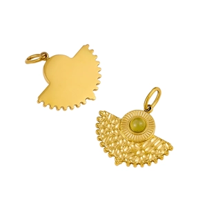 Détail d'un pendentif doré en forme d'éventail avec relief et pierre naturelle verte