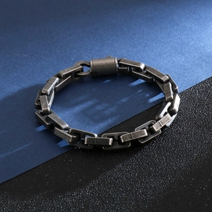 Macro detail of men's geometric chain bracelet in antique silver steel with vintage texture