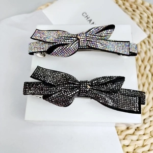 Detail of elegant bow hair clips with shimmering crystals in silver and black finishes