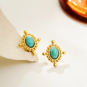 Macro detail of vintage gold oval earrings with turquoise stone and beaded texture