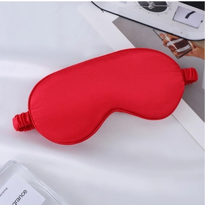 Detail of red faux silk sleep mask showing shiny smooth texture and elastic strap