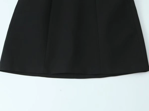 Gros plan macro sur les coutures de l'ourlet d'une robe courte tissée noire