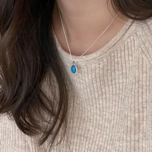 Minimalist 925 sterling silver necklace with oval turquoise pendant worn on a model