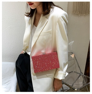 Detail of pink sequin box clutch bag with silver chain strap on white blazer outfit