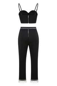 Detail of high-waisted black trousers with silver chains and sparkling rhinestone fringe
