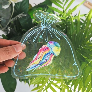 Detail of holographic rainbow jellyfish suncatcher sticker reflecting colorful light prisms