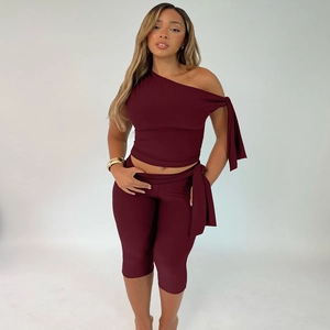 Detail of burgundy one-shoulder top and matching cropped leggings set in soft stretch fabric