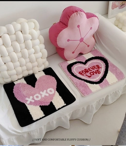 Cosy plush heart-shaped seat cushions and floral pillows on a white sofa setting