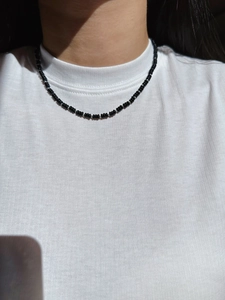 Detailed view of beaded necklace featuring glossy black beads and silver metal spacers