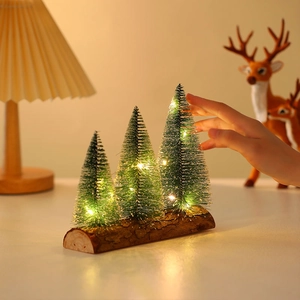 Mini lit Christmas trees on wood base with warm LED lights and snowy green needles