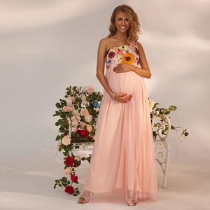 Detail eines rosa One-Shoulder Umstandskleides mit Blumenstickerei und Netzrock